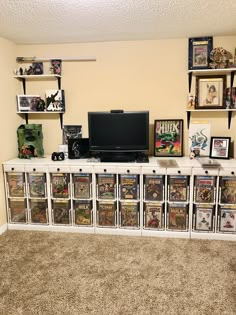 a television sitting on top of a white entertainment center filled with comic books and dvds