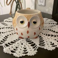 an owl mug sitting on top of a doily