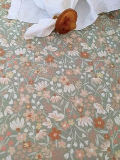 a stuffed animal sitting on top of a bed next to a roll of toilet paper