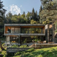 a modern house in the middle of a wooded area with stairs leading up to it