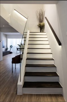 a white staircase with black handrails leading up to the second floor