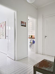 an empty room with white walls and wooden floors