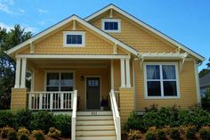 a yellow house with steps leading to the front door