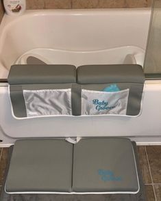 a bath tub with two seat covers on top of it and a towel holder in the middle