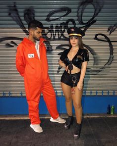 a man in an orange jumpsuit standing next to a woman wearing black and white