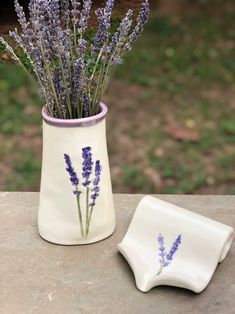 lavender flowers in a vase next to a plate