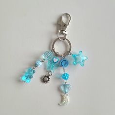 a keychain with various charms hanging from it's side on a white surface