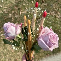 a person holding flowers in their hand with the stems still attached to them and two wooden sticks sticking out of it