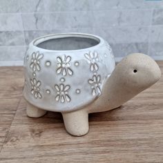 a ceramic turtle planter sitting on top of a wooden table