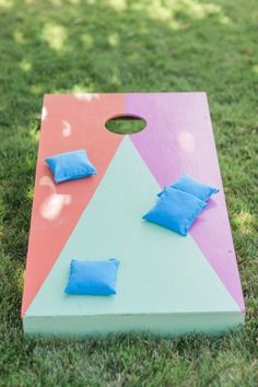 a cornhole game set up in the grass with blue pillows on it and one piece missing