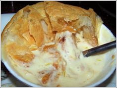 a bowl filled with food sitting on top of a table next to a knife and fork