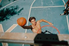 a young man is playing basketball in an indoor court with his hands on the rim