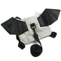 a white and black bat shaped dog harness with leash attached to it's back