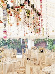 an image of a wedding venue with flowers hanging from the ceiling and tables set up