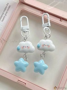 two little blue and white clouds are hanging from the handles of these cute clip - on earrings