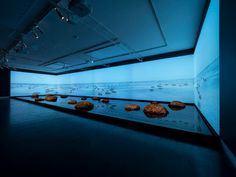 an empty room with rocks on the floor and water in the background at night time