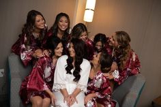 a group of women in red and white robes sitting on top of a gray couch