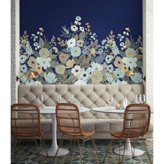 a restaurant with floral wallpaper on the walls and two chairs in front of it