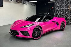 a pink sports car parked in a garage