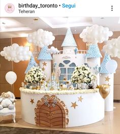 a birthday cake that looks like a castle with lots of balloons on top of it