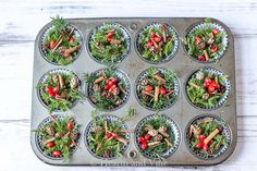 a muffin tin filled with cupcakes topped with mushrooms and veggies