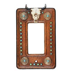 a light switch cover with a cow's skull on the front and turquoise beads