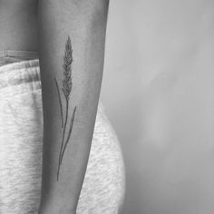 a black and white photo of a woman's arm with a flower tattoo on it