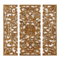 three gold metal wall panels with floral designs on the sides and an ornate design in the middle