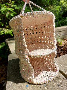 a crocheted basket hanging from a tree