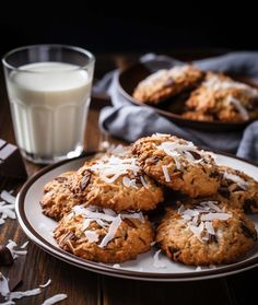 chocolate chip cookies with coconut on a plate next to a glass of milk