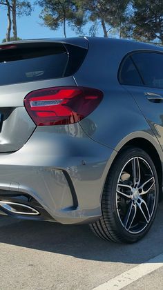 the rear end of a silver car parked in a parking lot