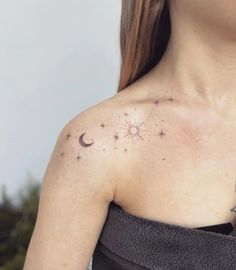 a woman's chest with stars and moon tattoos on it