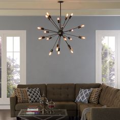 a living room filled with furniture and a chandelier hanging over the top of it