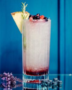 a tall glass filled with ice and fruit