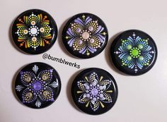 four black buttons with colorful flowers painted on them