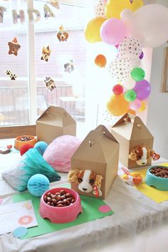 a table topped with lots of food and balloons