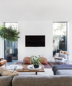 a living room filled with furniture and a flat screen tv mounted on the wall over a fireplace