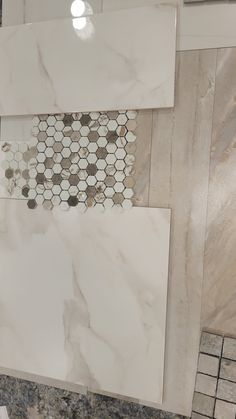 some white and brown marble tiles on the wall in a room with tile flooring