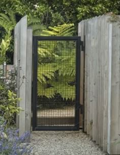 an open gate in the middle of a garden