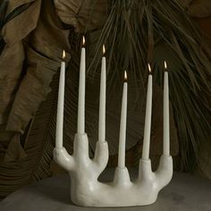 four white candles are in the shape of hands