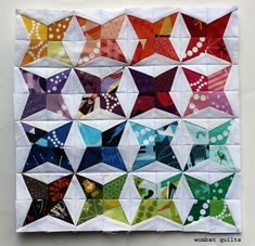 a quilted wall hanging with many different colored kites on it