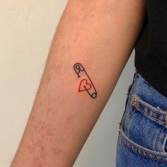 a small tattoo on the arm of a woman with a knife and heart in it