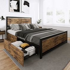 a bed with two drawers underneath it in a white and black bedroom setting on hardwood flooring