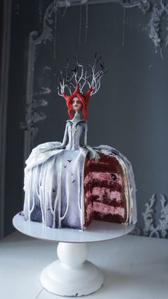 a red velvet cake with white icing and frosting on top is decorated with an elf's head