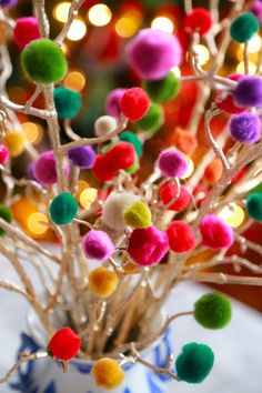 a vase filled with colorful pom - poms on top of a table