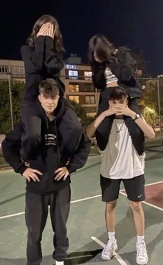 three people standing on a tennis court with their arms around each other's shoulders