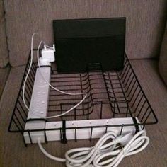 a wii game system sitting on top of a wire basket in front of a couch