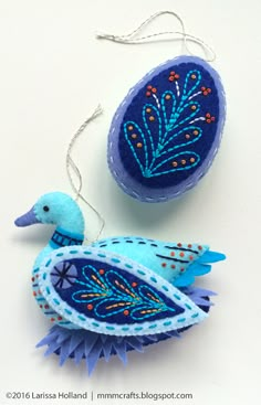 an ornament shaped like a blue bird with feathers on it's tail