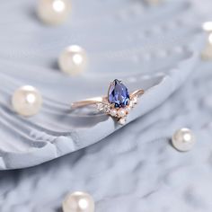 a ring with a blue stone surrounded by pearls