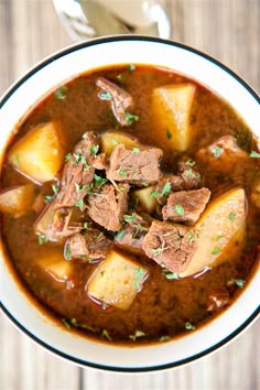 slow cooker steak and potato soup in a white bowl with text overlay that reads, slow cooker steak and potato soup